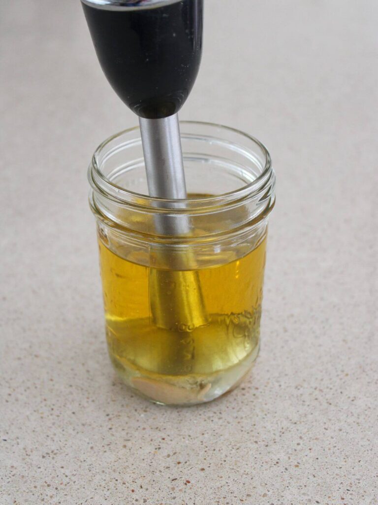 ingredients in a mason jar with an immersion blender ready to blend