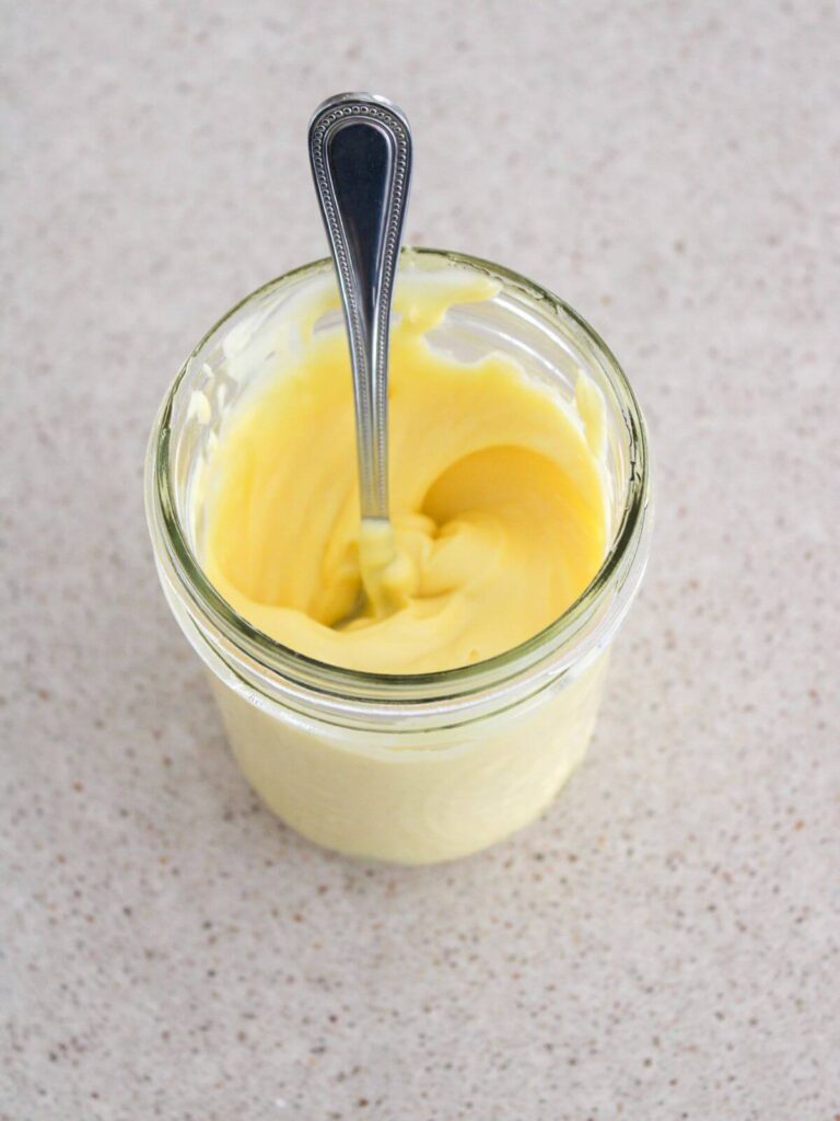mayo in a mason jar in a silver spoon ready to use
