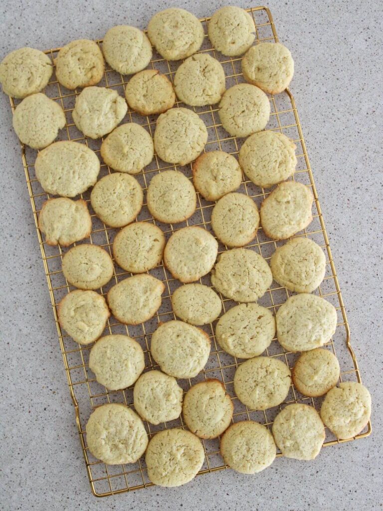 cookies cooling and resting on a golden cooling rack