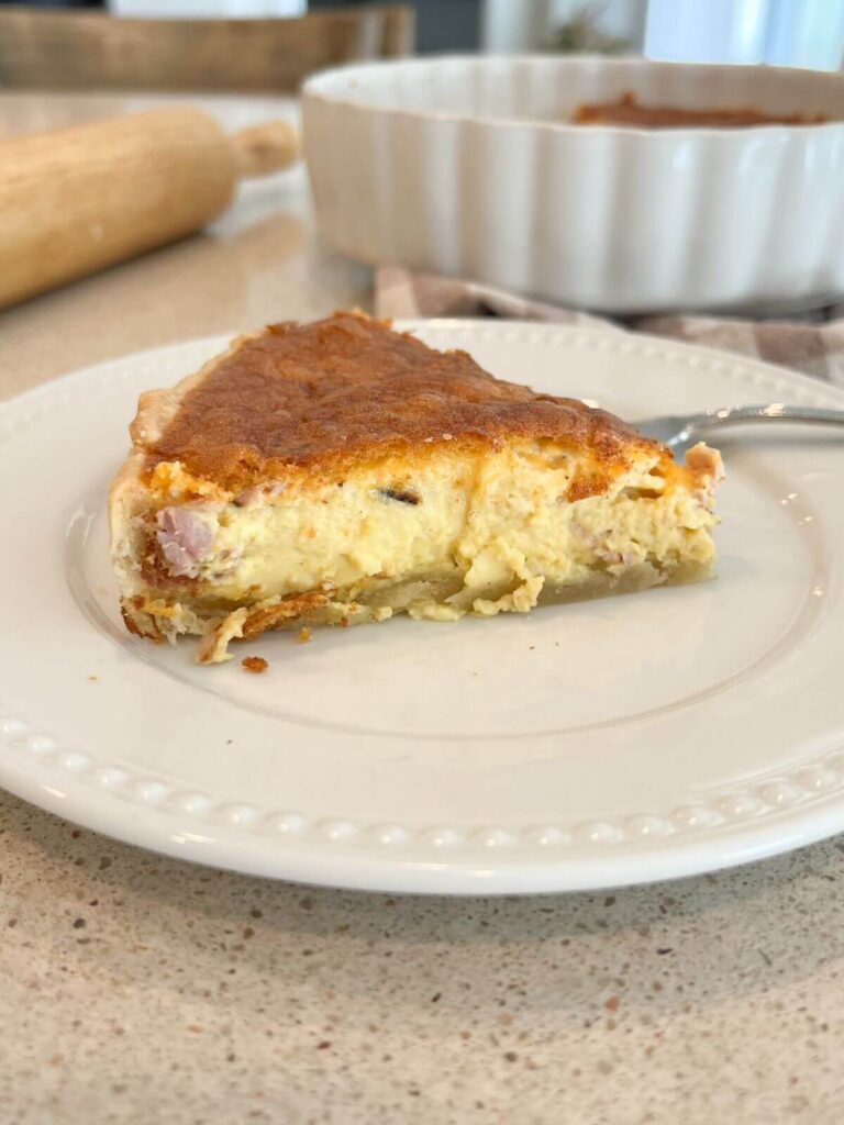 Quiche cut and on a white plate with fork 