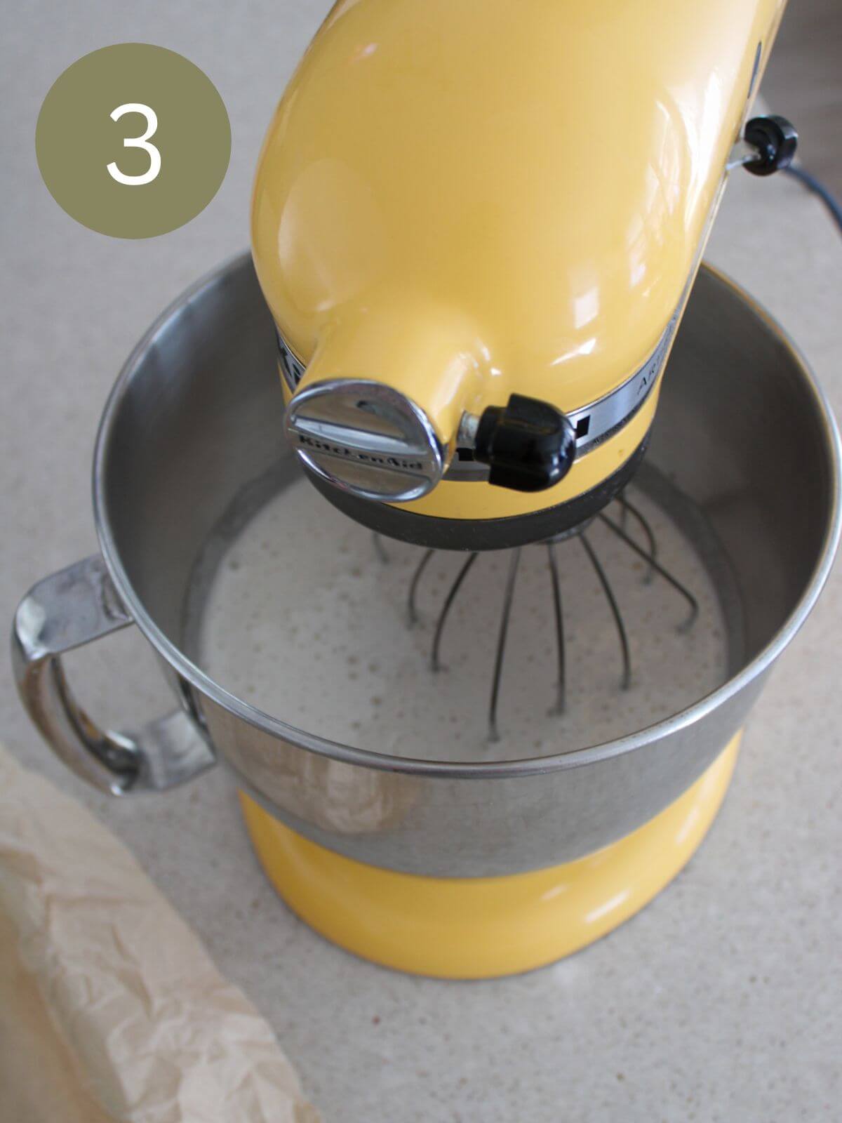 the marshmallow mixture in a yellow stand mixer