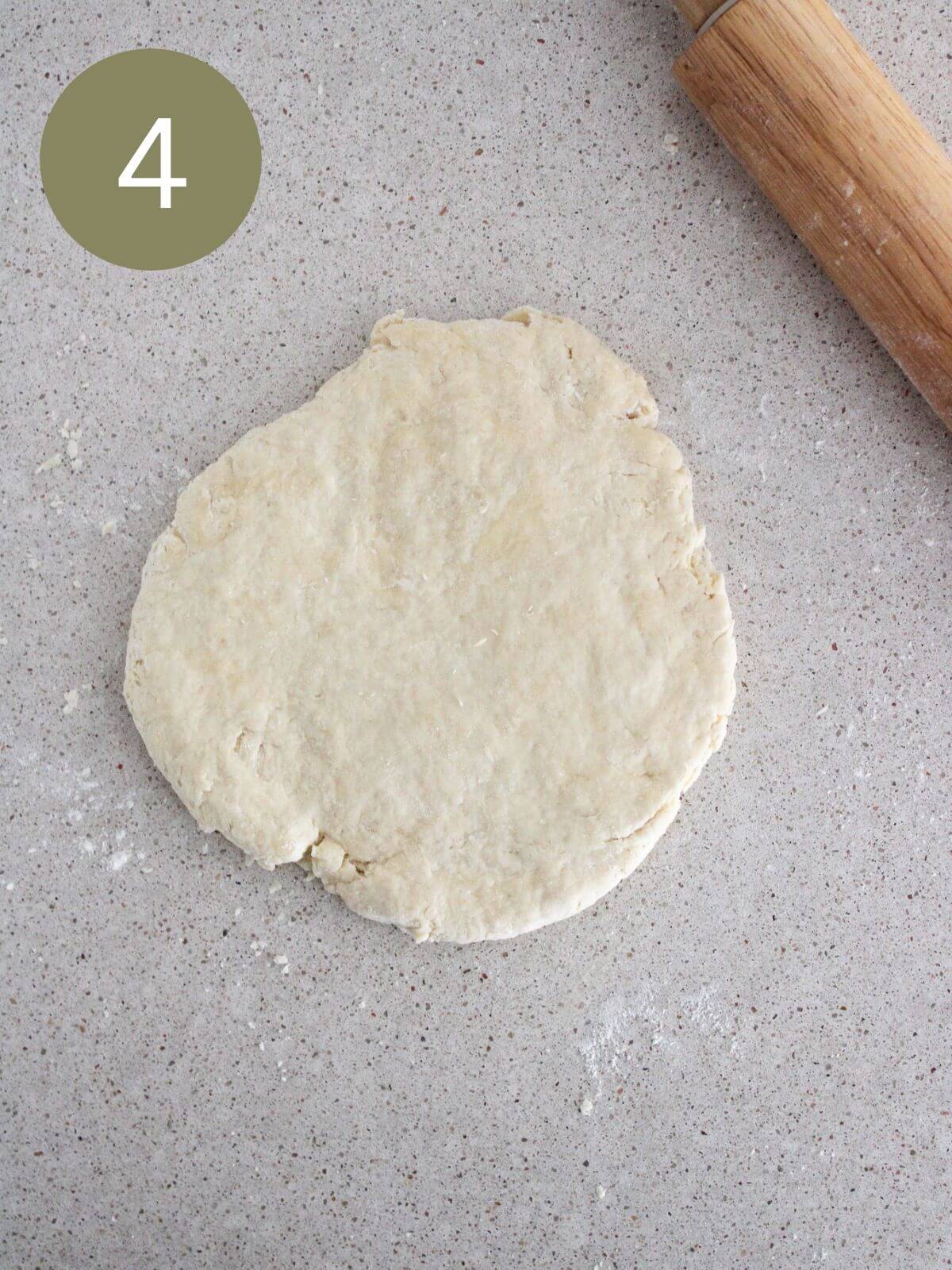 dough rolled out and ready to make biscuits with a rolling pin off to the side