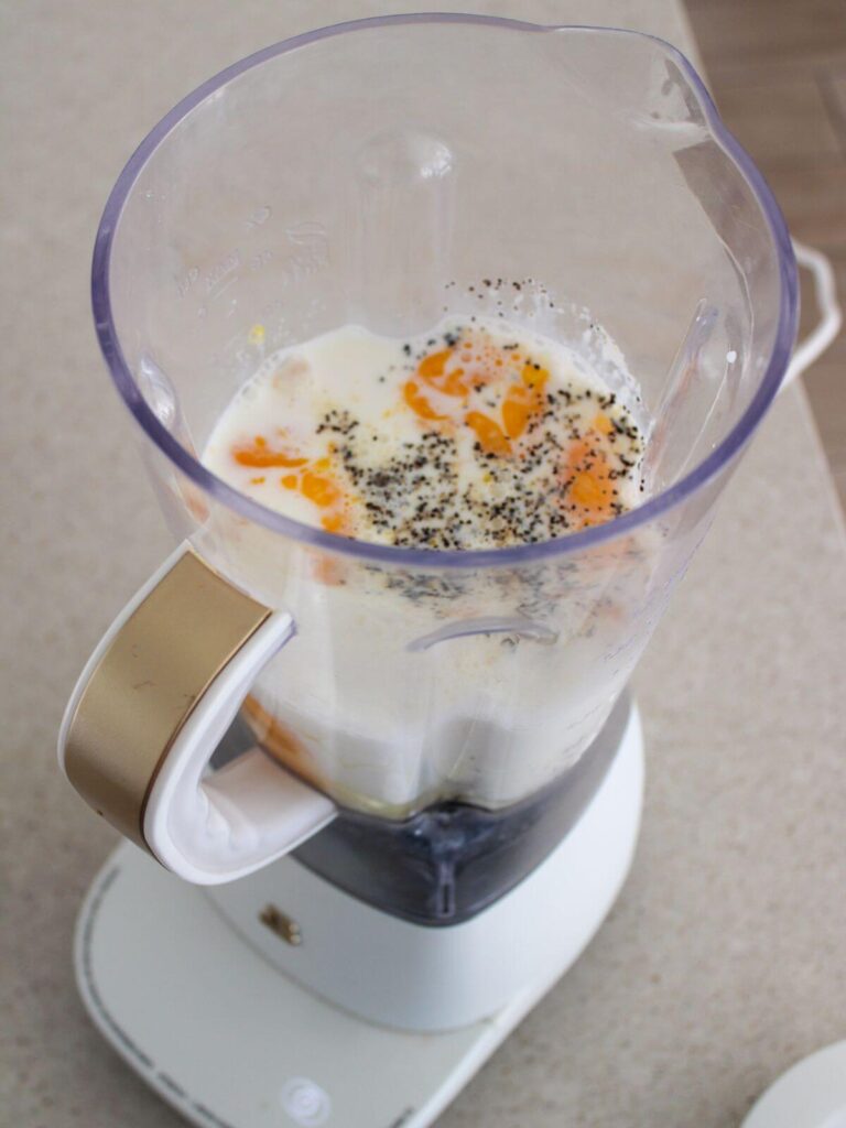 eggs, milk, cottage cheese, salt, pepper, and garlic powder in a white blender ready to blend