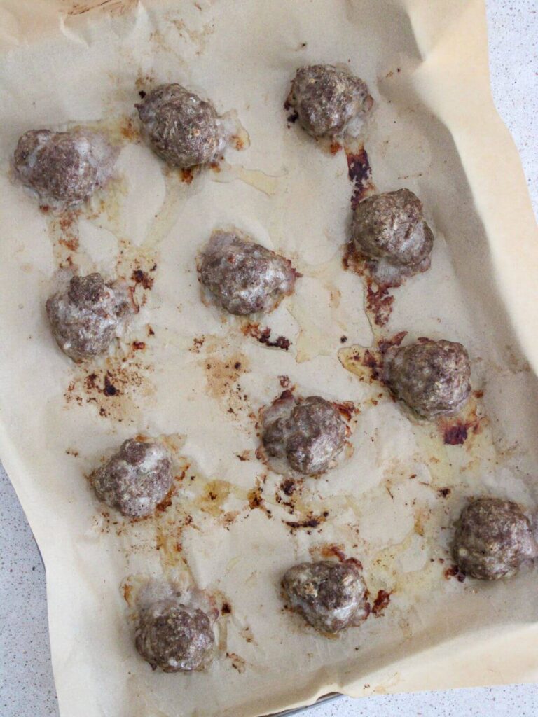 meatball baked on a parchment lined baking sheet