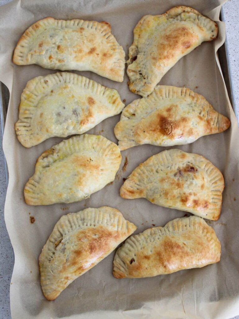 baked chicken bacon ranch pockets cooling on a parchment lined sheet pan