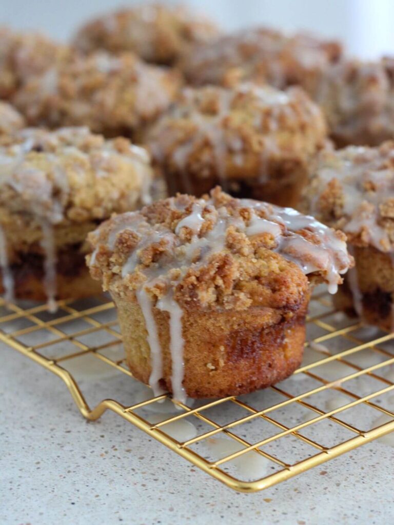 Coffee cake muffins ready to eat on a golden cooling rack