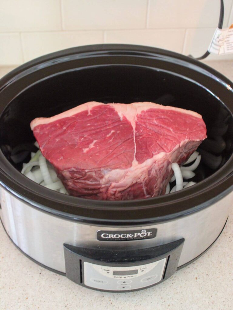 roast on top of a bed of onions inside a crockpot