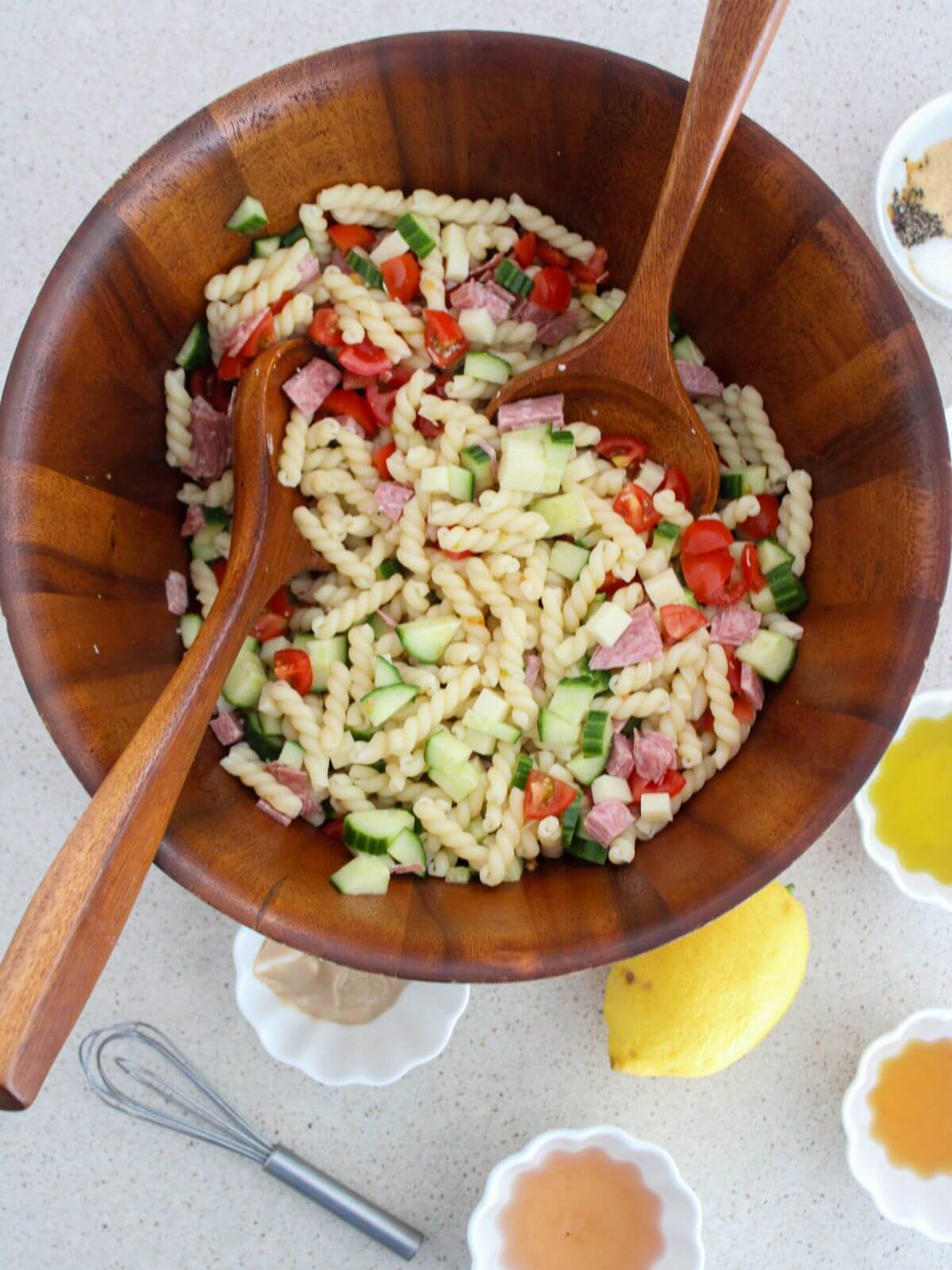 All of the ingredients mixed together in a wooden bowl with two wooden spoons