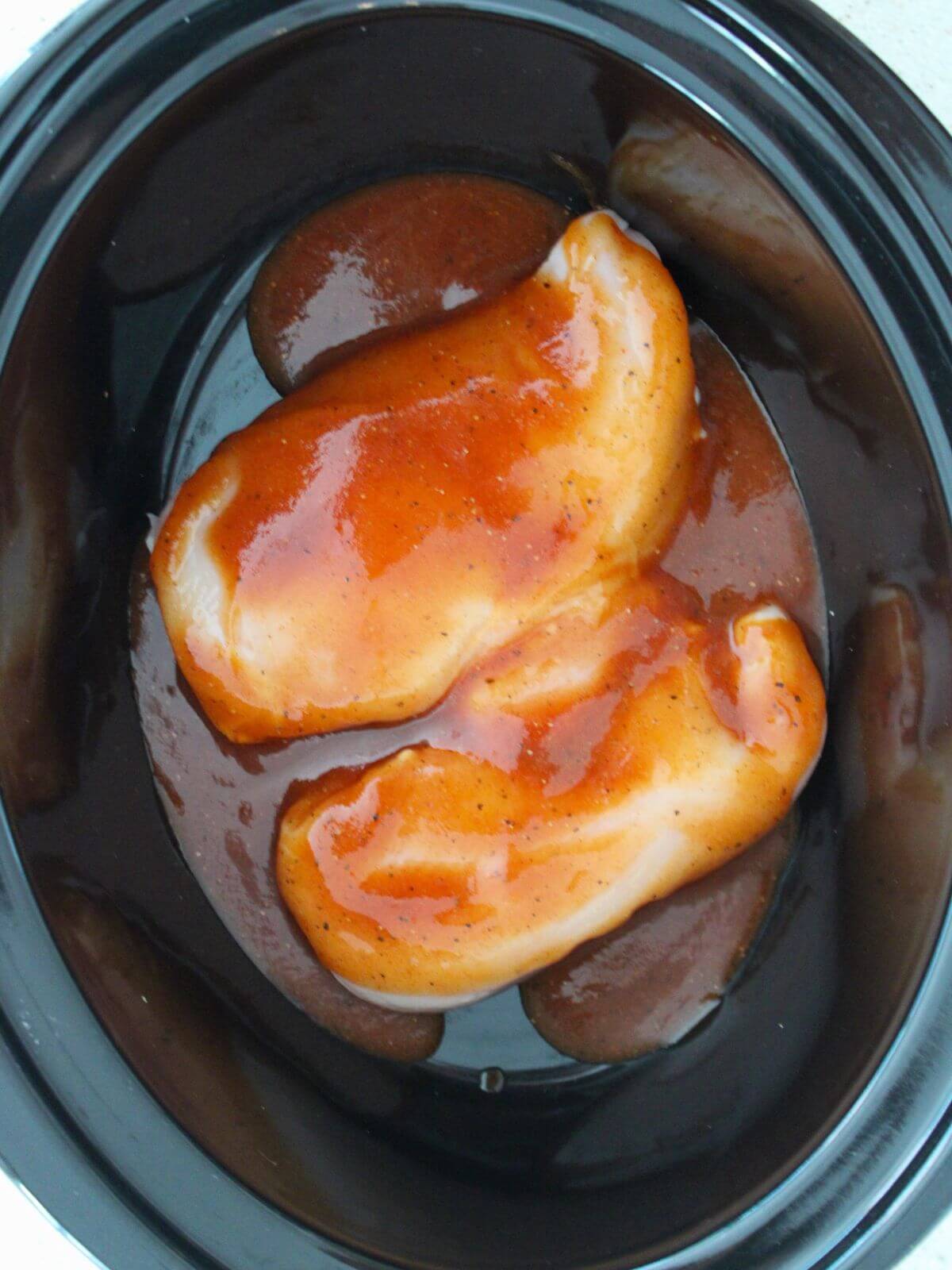 chicken breasts in the crockpot topped with the bbq mixture
