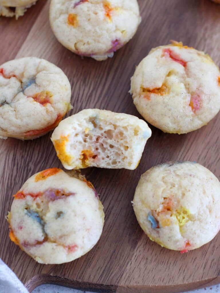 muffins on a wooden cutting board with a bite taken out