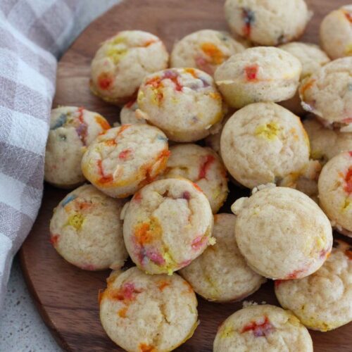 Mini Maple Muffins stacked on a wooden cutting board with a plaid napkin next to it