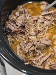 Slow Cooker Italian Beef in a crockpot with a fork