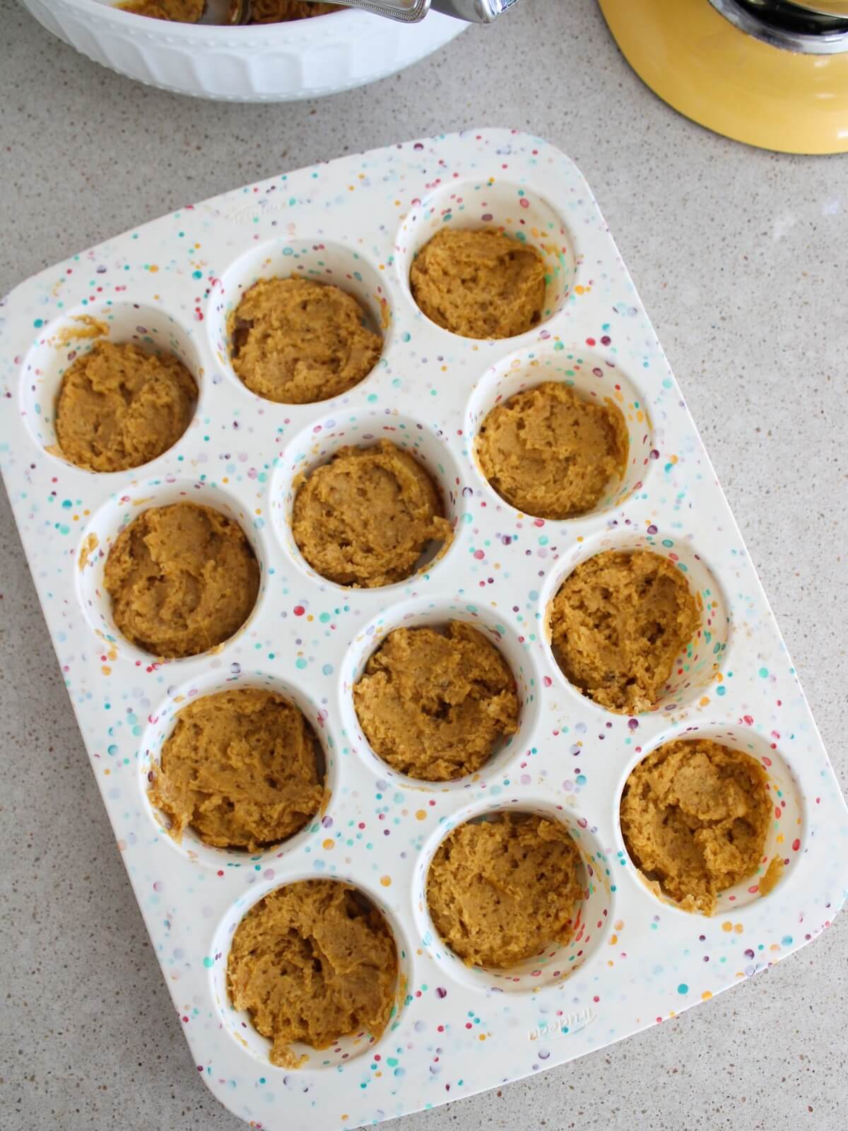 spreading half the batter in a muffin pan